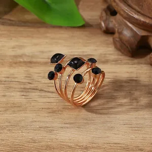 Detailopname van meerlaagse roségouden spiraalring met zwarte edelstenen decoratie