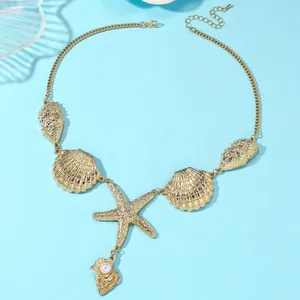 Detail of golden ocean theme necklace with starfish pendant, shell motifs and white pearl