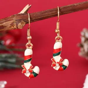 Macro view of candy cane Christmas earrings with enamel stripes and bow detail