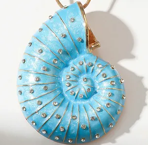 Macro shot of sky blue enamel conch pendant with gold detailing and crystal stones
