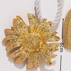Golden flower pendant with hammer texture on a white rope for beach vacation styles