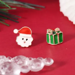 Detail of asymmetric Christmas earrings featuring Santa Claus and a green gift box with rhinestones