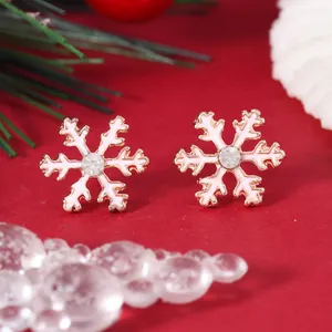 Detailed view of rose gold snowflake earrings with white enamel and sparkling gemstone