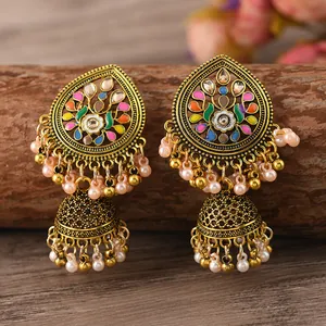 Makro-Detail von indischen Jhumka-Ohrringen mit Emaille-Blumen und Perlenquasten