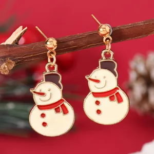 Detailed view of festive snowman earrings made of alloy enamel hanging on a wooden branch