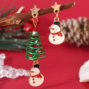 Detail of asymmetrical Christmas earrings with gold star, green tree and enamel snowman charms