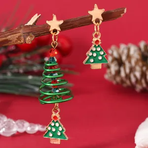 Detailed macro shot of Christmas tree drop earrings with green enamel and spiral beads
