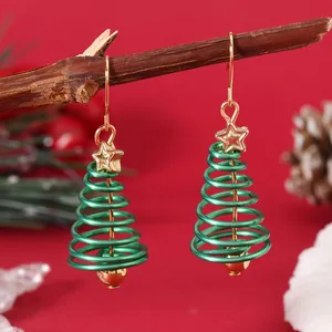 Detailed close-up of a Christmas tree spiral earring with gold star on a red backdrop