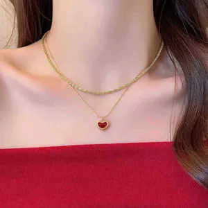 Collana a doppio strato dorata con ciondolo a cuore rosso e catena testurizzata