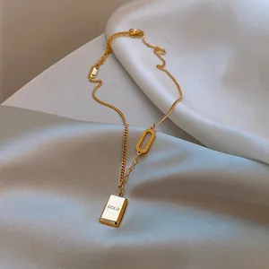 Vue détaillée du pendentif lingot d'or avec gravure GOLD sur chaîne en acier titane