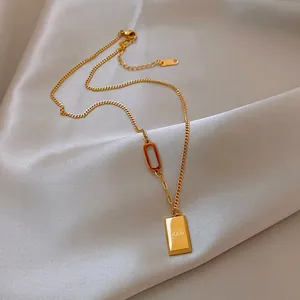 Détail du pendentif lingot d'or avec gravure GOLD sur fond en tissu de soie