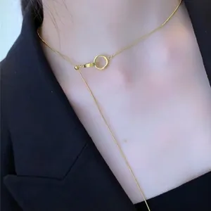 Minimalist golden ring tassel necklace with adjustable slider chain worn on model