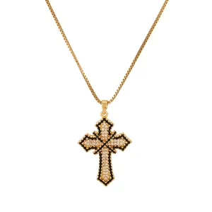 Detail of gold box chain necklace featuring a black and white zircon cross pendant