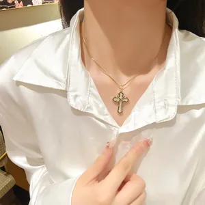 Exquisite gold cross necklace with zircon pave on woman neck with white silk shirt