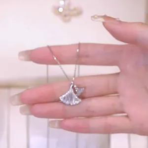 Vue macro du collier avec pendentif feuille de ginkgo argenté et cristaux pavés
