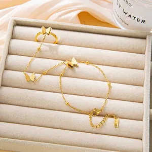 Gold butterfly ring bracelet chain with frosted charms and beaded strand on velvet tray