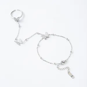 Silver butterfly finger bracelet with matte finish and adjustable ring on white background