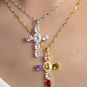 Collier croix évidée avec zircons colorés et pierres argentées sur une fine chaîne en métal