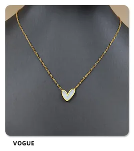 Macro detail of heart pendant with iridescent white mother of pearl and gold chain