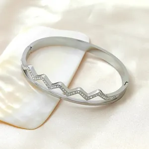 Elegant silver-tone stainless steel wave-shaped bangle with sparkling rhinestones
