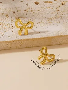 Detailed view of gold bow-shaped stud earrings showing 1.5cm measurement scale