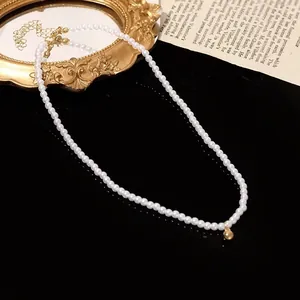 Detail of single strand pearl necklace with gold ball pendant and adjustable clasp