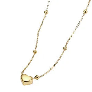 Elegant gold heart pendant necklace featuring round gold bead accents on a refined chain
