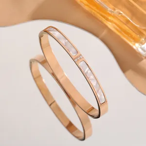 Rose gold stainless steel bangle with white mother-of-pearl inlay and three small crystals
