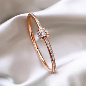 Brazalete de acero inoxidable en oro rosa con circonitas brillantes sobre satén