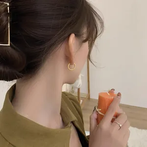 Französische goldene gedrehte Creolen und minimalistischer Silberring an Model