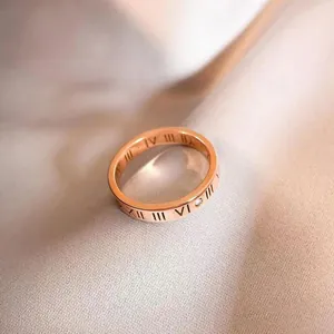 Rose gold Roman numeral ring with sparkling crystal inlay on silk background