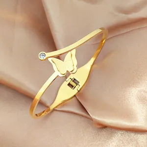 Detail of golden butterfly hinge bracelet with matte finish and small zircon accent