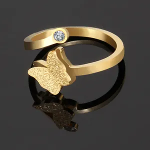 Macro detail of golden butterfly ring with matte finish and sparkling zircon stone