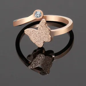 Detail of rose gold butterfly ring with frosted finish and sparkling round stone