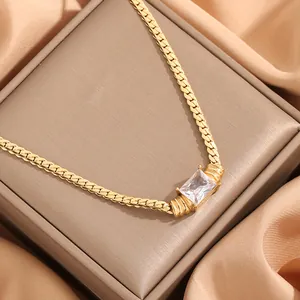 Lujoso collar de oro con gema rectangular transparente en joyero de color marrón