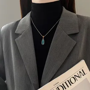 Elegante collar de cadena dorada con colgante de piedra preciosa verde azulado de gota