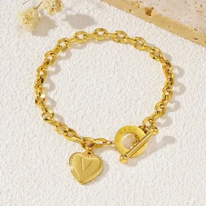 Gouden roestvrijstalen schakelarmband met hartbedeltje letter V en gegraveerde OT-sluiting