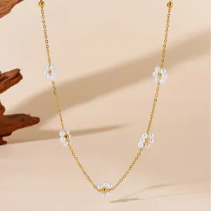 Elegant gold necklace featuring five delicate pearl flowers on a minimalist chain
