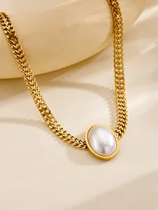 Detailed macro shot of vintage gold thick chain necklace with large oval white pearl pendant