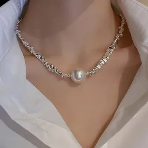 Modern irregular silver bead necklace with large central white pearl on a model