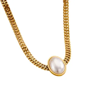 Chunky gold braided chain necklace featuring a large oval pearl pendant on white background