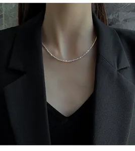 Detail of shimmering silver sparkling chain necklace worn with an elegant black outfit
