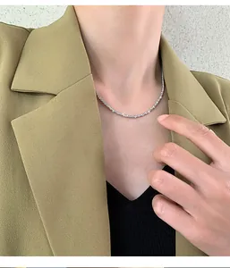 Detailed close-up of a sparkling silver cauliflower chain necklace worn on neck