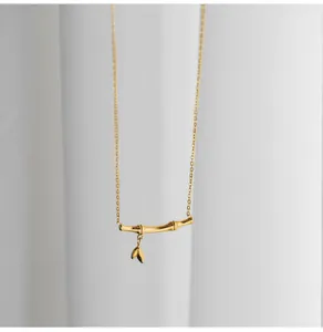 Detail of golden bamboo pendant with two leaf charms on a delicate link chain necklace