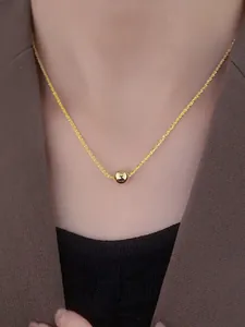 Macro detail of a sleek gold ball pendant on a sparkling starry titanium steel chain