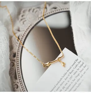 Close-up of golden bamboo joint pendant necklace with a leaf charm and fine link chain