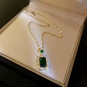 Macrobeeld van smaragdgroene kristallen hanger ketting in een crèmekleurig doosje