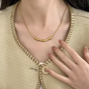 Elegante goldene Titanstahlkette mit unregelmäßigem Faltenanhänger an einer Schlangenkette