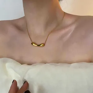 Detail einer goldenen Halskette mit unregelmäßigem Anhänger und polierter Metallstruktur am Modell