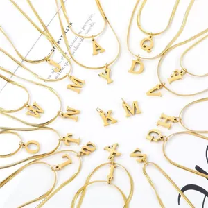 Dettaglio di ciondoli con lettere A-Z dorate su eleganti collane a catena snake